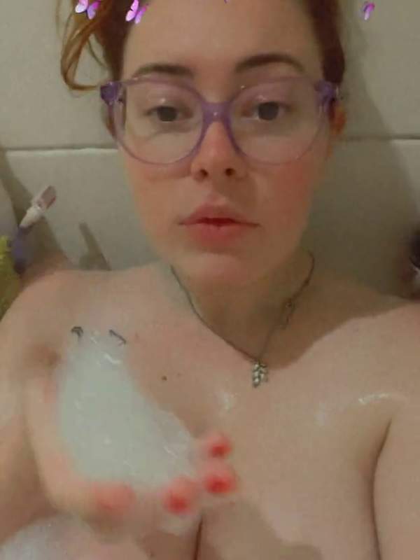 Deine Liebling mit den großen Titten und Brille genießt ein Bad