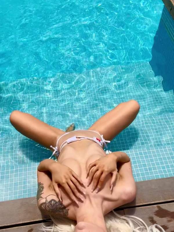 Blonde Blondine mit kleinen Titten im Pool