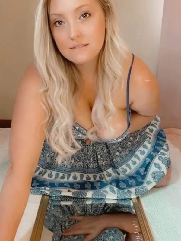 Blau gekleidete Blondine mit riesigen Titten spielt vor dem Spiegel